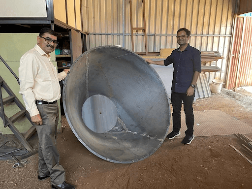 Kul Kauwid and Gokul Gaikwad from Varhad Capital, holding a artisanal kiln for biochar production